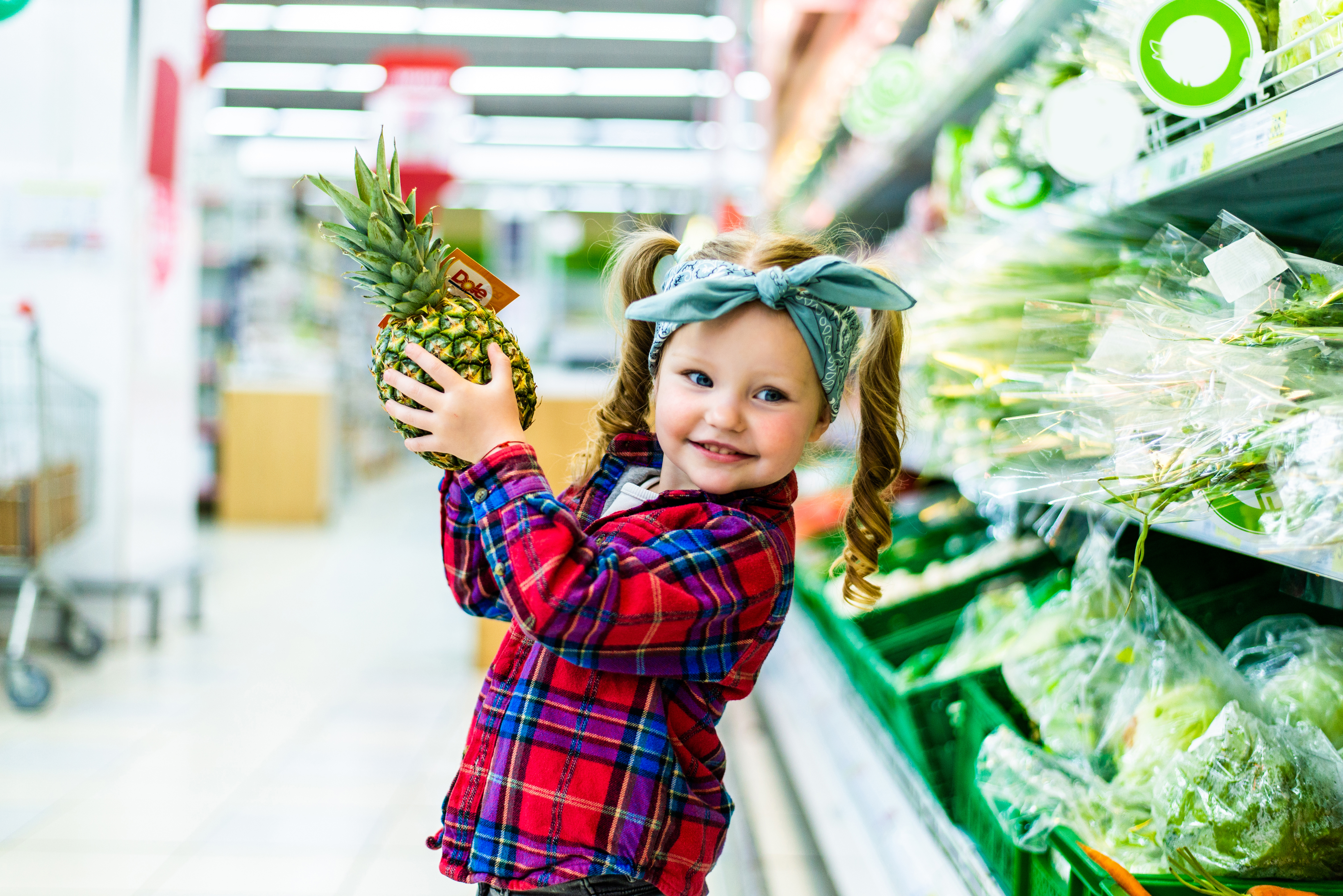 little-kid-standing-with-pineapple-supermarket