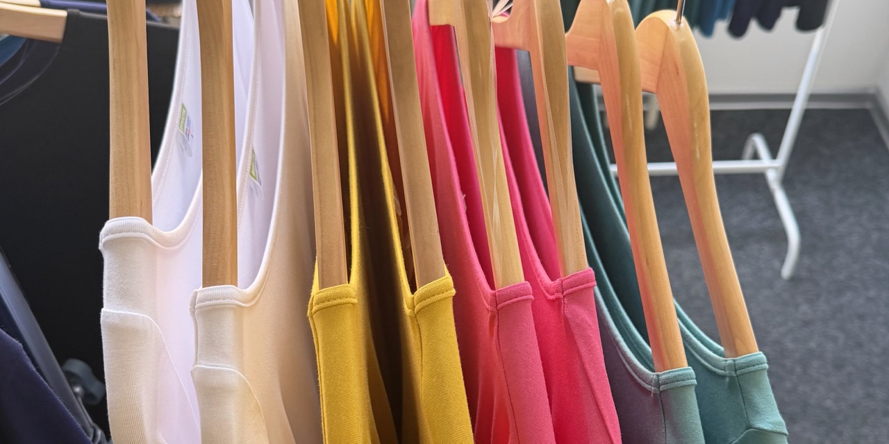 Barevná bambusová tílka na ramínkách v prodejně Bambutik v Praze