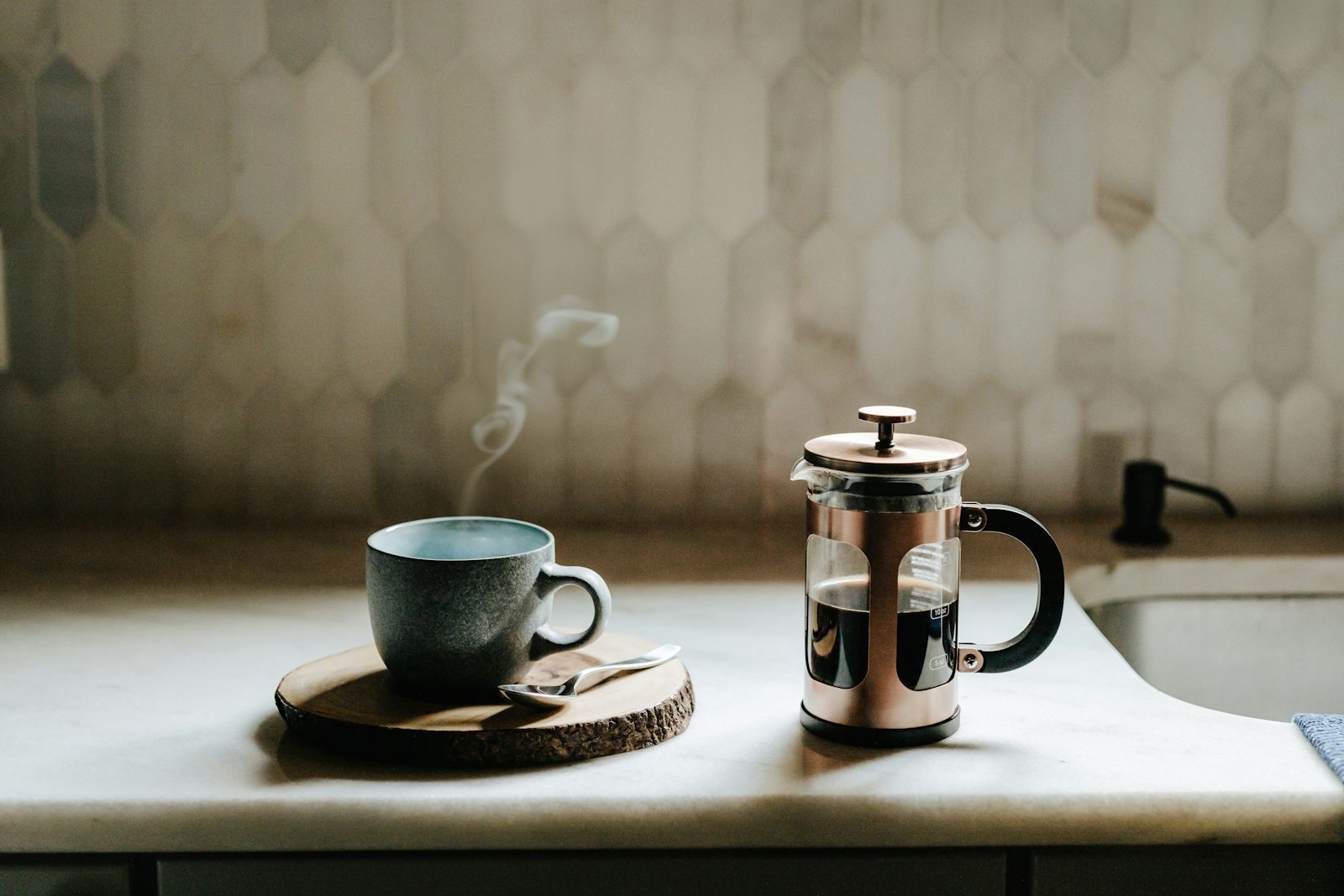 French press a šálek kávy na stole