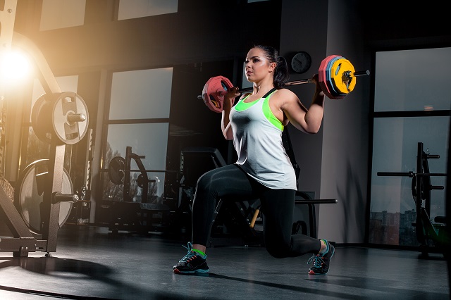 fit-young-woman-lifting-barbells-looking-focused-working-out-gym