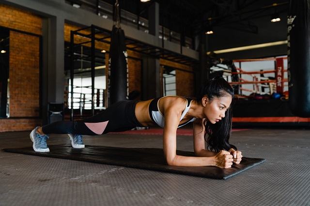 happy-young-asian-lady-doing-plank-fat-burning-workout-fitness-class