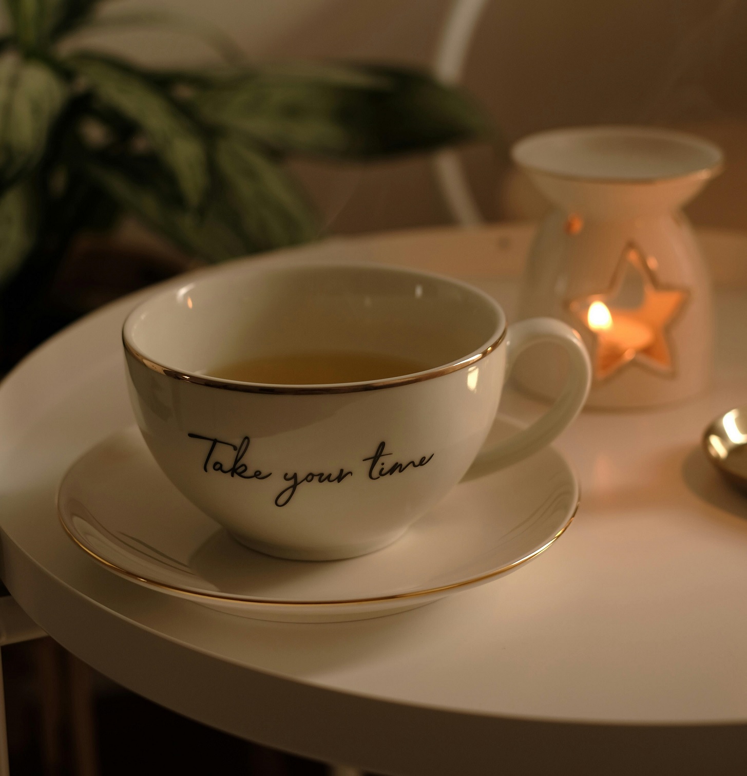 Šálek čaje při večerním relaxu se svíčkou a klidnou atmosférou