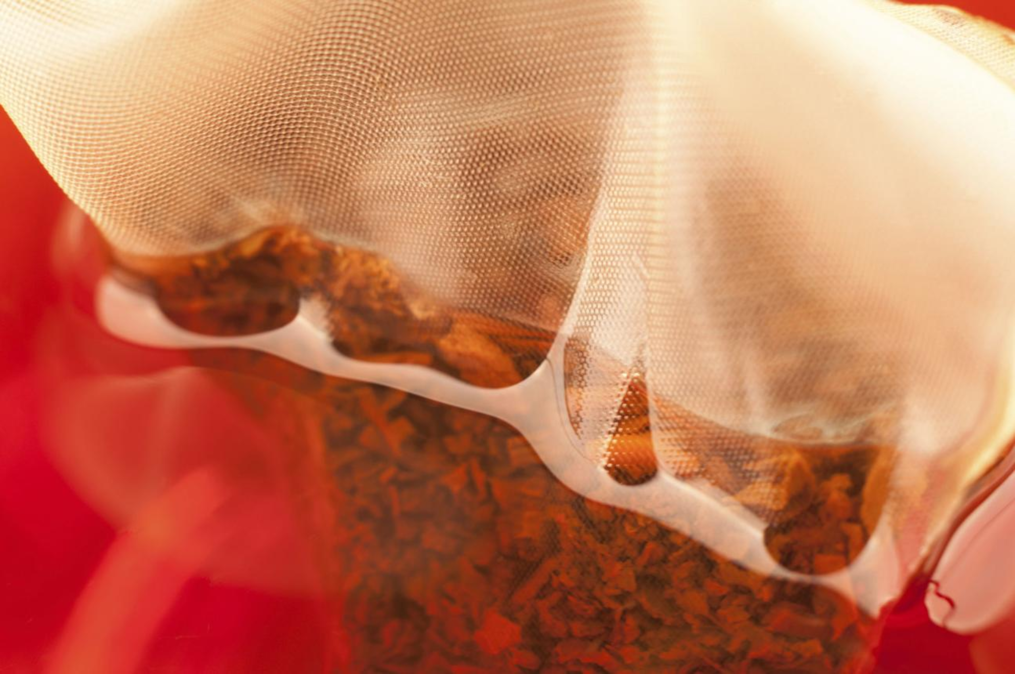 Detail čajového sáčku v horké vodě s jemnou strukturou materiálu