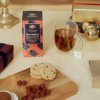 Bylinkový čaj Whittard Gingerbread servírovaný s hrnkem čaje a cukrovím.