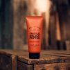 Pánský sprchový gel Scottish Fine Soaps Thistle & Black Pepper na dřevěném stole