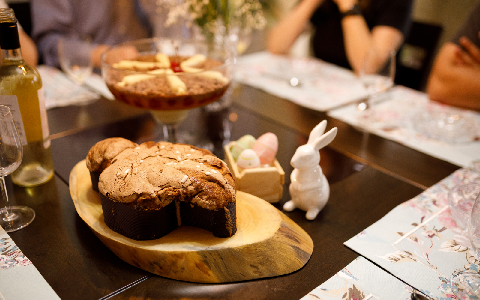 Talianska Veľká noc pri stole s rodinou a tradičným dezertom Colomba di Pasqua