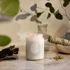 Vonná sviečka Voluspa Eucalyptus & White Sage zapálená v zenovej atmosfére s bylinkami a šalviou