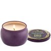 Vonná sviečka Voluspa Palo Santo Spells v tmavo fialovej plechovej dóze, otvorená a horiaca.