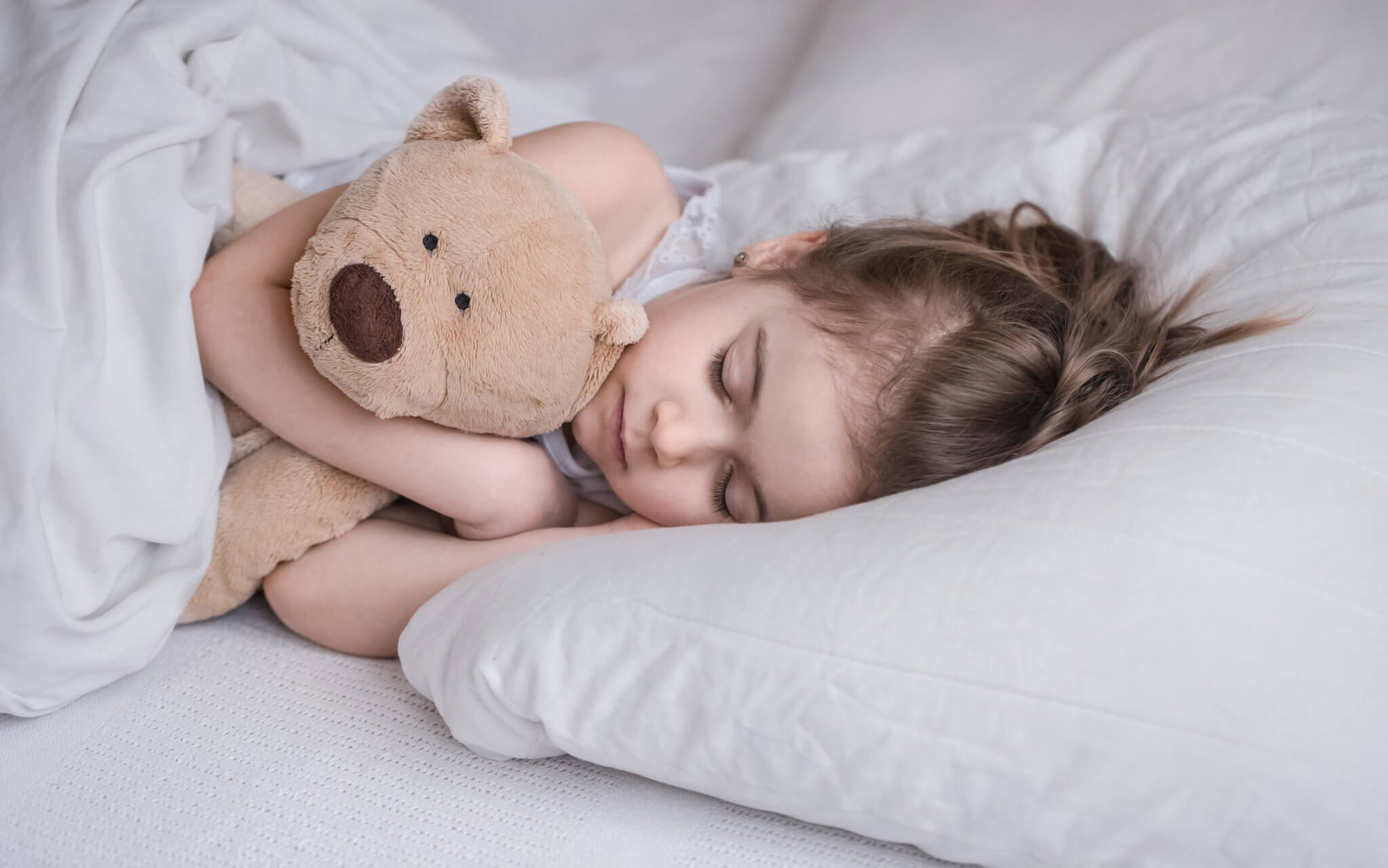 cute-little-girl-sleeps-sweetly-white-cozy-bed-with-soft-bear-toy-concept-children-s-rest-sleep-2048x1281