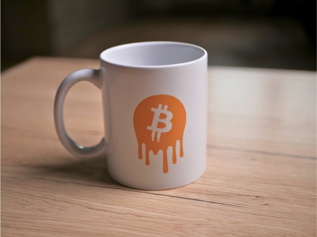 Hrnek s rozteklým Bitcoin logem