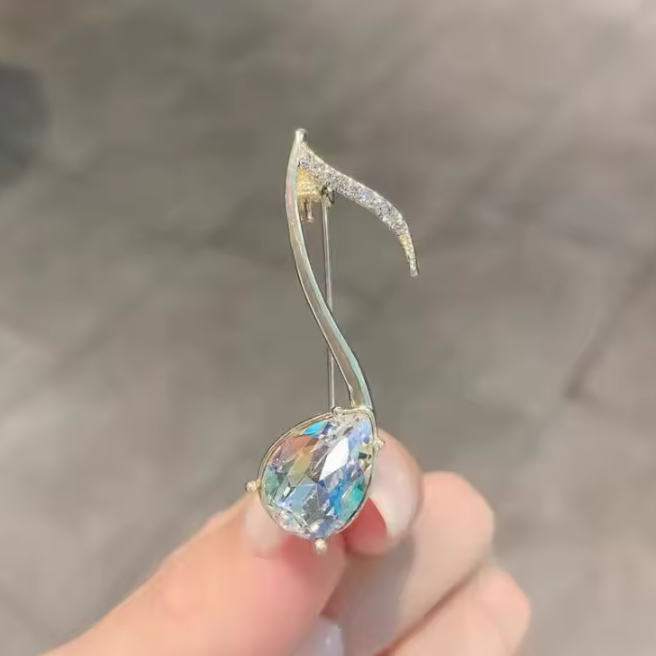 Pozlátená brošňa v tvare noty s kryštálmi