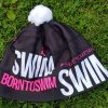 Wintermütze schwarz BornToSwim® mit rosa Logo und weißem Bommel