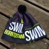 Winter cap BornToSwim® black with yellow logo and black pompom