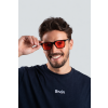 Smiling man adjusting sunglasses in studio