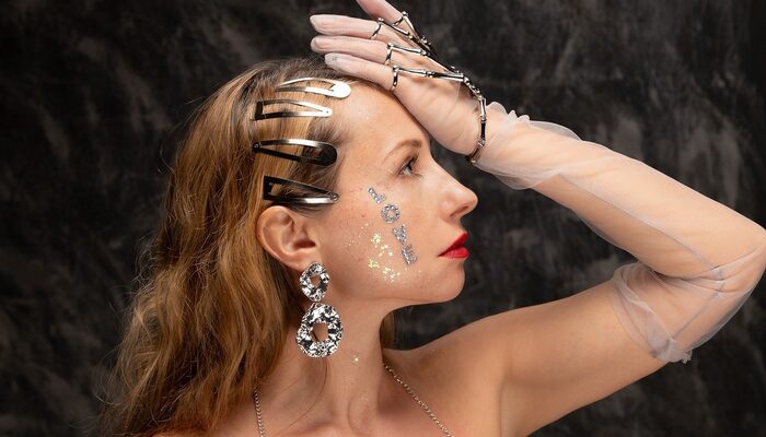 Žena s výrazným zlatým náhrdelníkem v jednoduchém bílém tričku