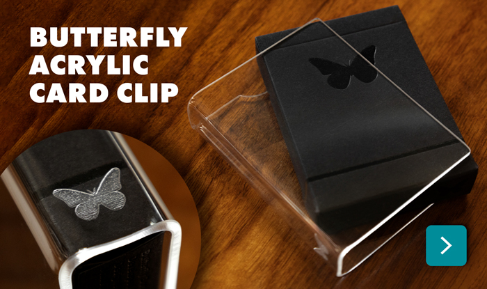 An acrylic card clip with a laser-etched Butterfly Playing Cards logo on the spine.