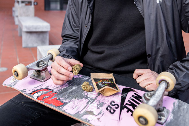 Květy konopí s obalem položené na skateboardu