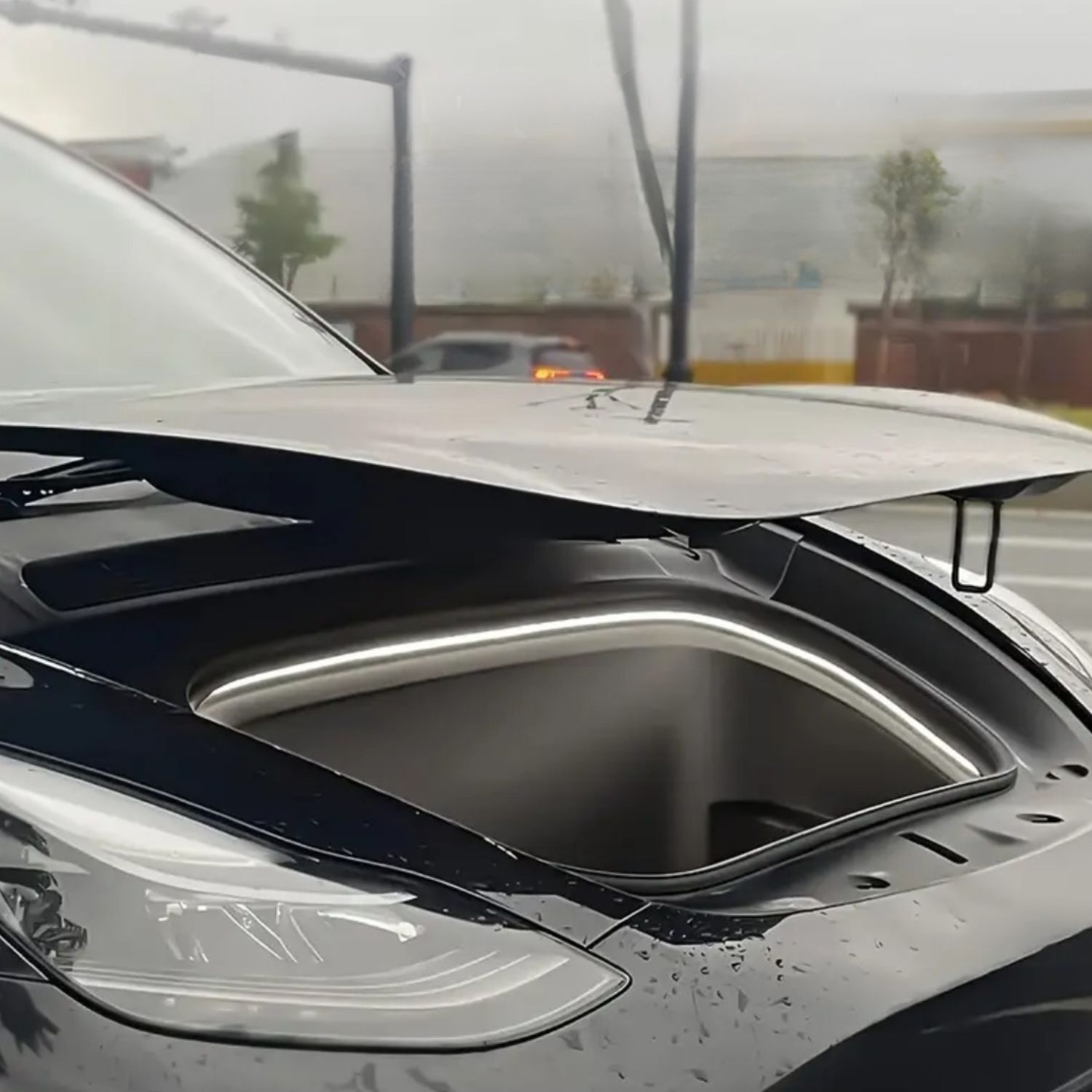 Komplexní pohled na vůz Tesla a její osvětlený přední kufr za dne dodávající moderní ambientní vzhled