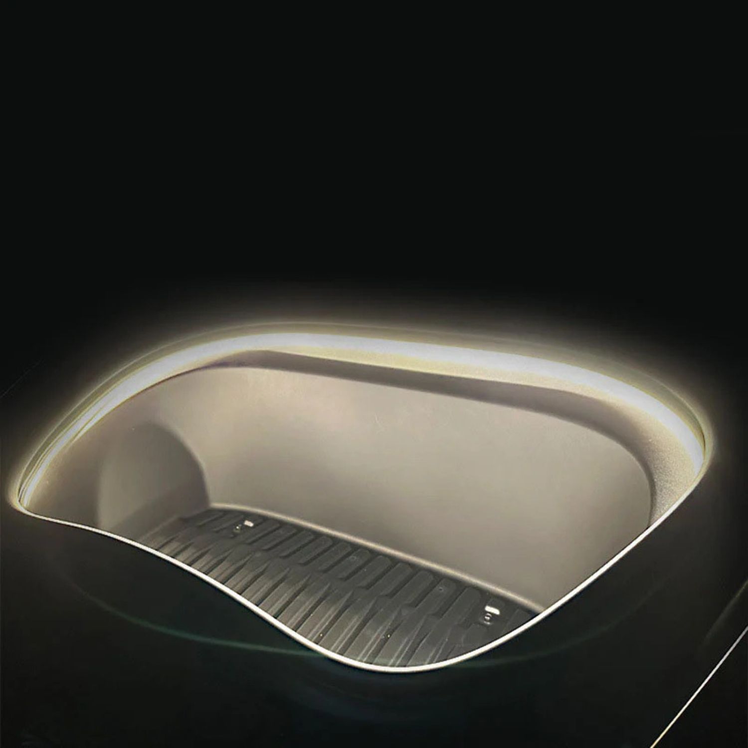 Detailní boční pohled na ohebný difuzní LED pásek instalovaný v hraně předního kufru Tesla