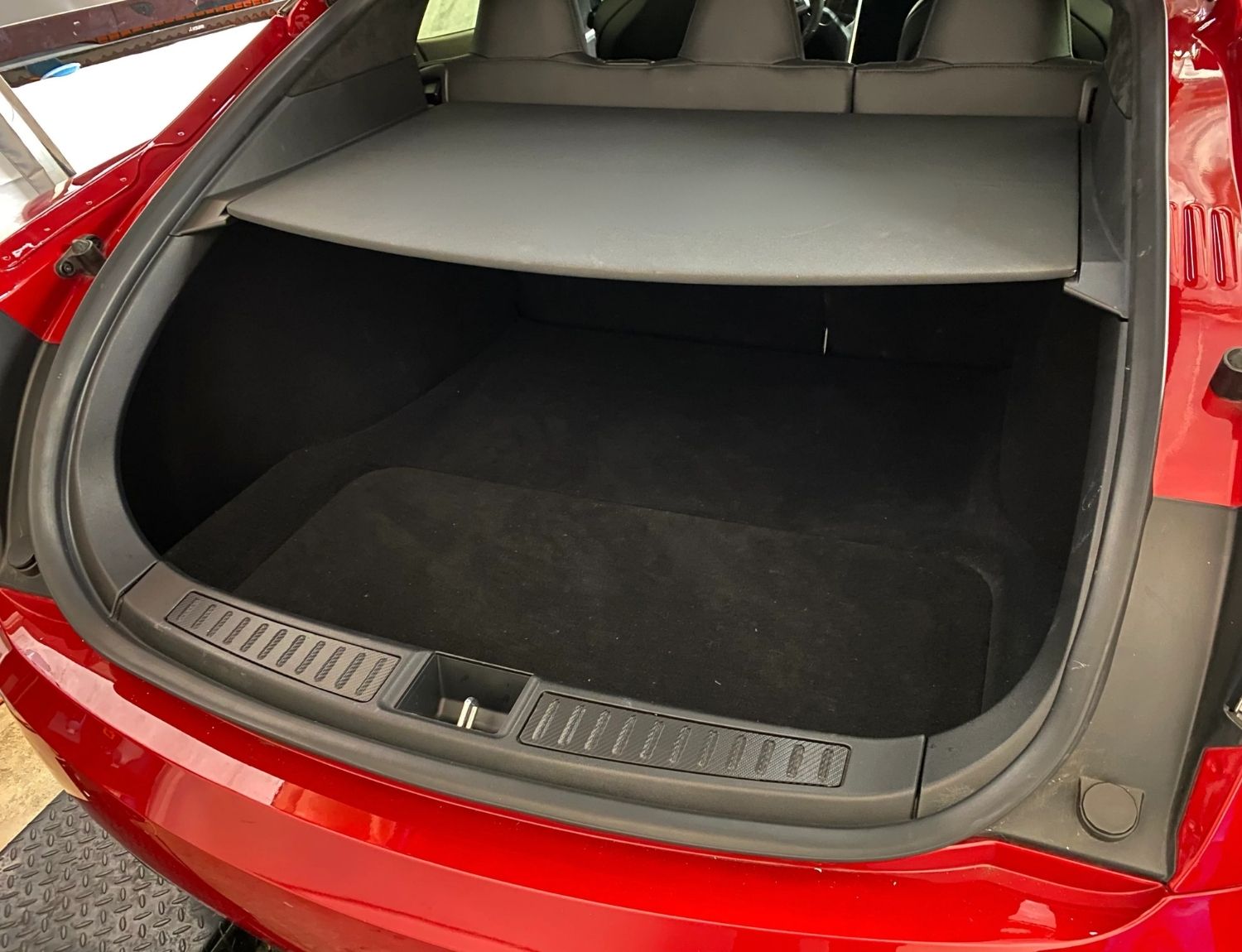 Pohled do kufru Tesla Model 3 se slabým továrním osvětlením