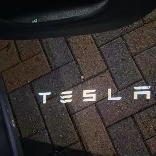 Uvítací nápis dveří Tesla v noci