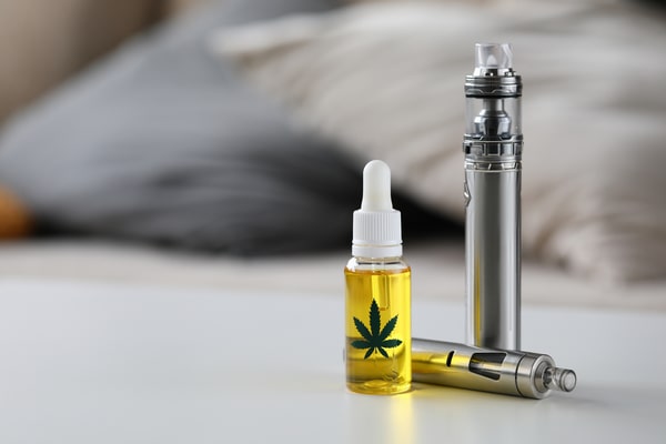 Organic-Extra-Virgin-cannabinoid-oil-with-vipe-pen-system-against-home-background