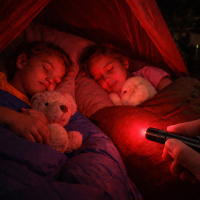  spici deti ve stanu pri cervenem nocnim svetle z baterky
