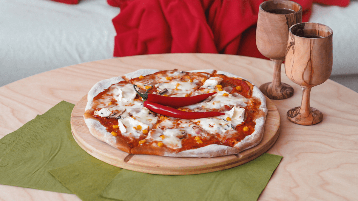 Domácí pizza servírovaná na dřevěném prkénku