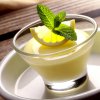 DALL·E 2024 09 01 12.39.47 A realistic image of a lemon whisky panna cotta served in an elegant glass dish. The panna cotta is smooth and creamy, with a slight yellow hue from t