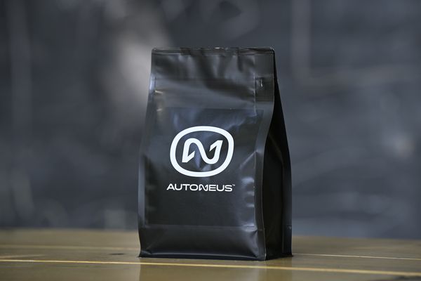 Káva s logom firmy Autoneus — čierny obal s potlačou