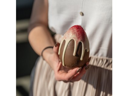 Mléčné vajíčko plněné malinou zdobené bílou čokoládou a malinou