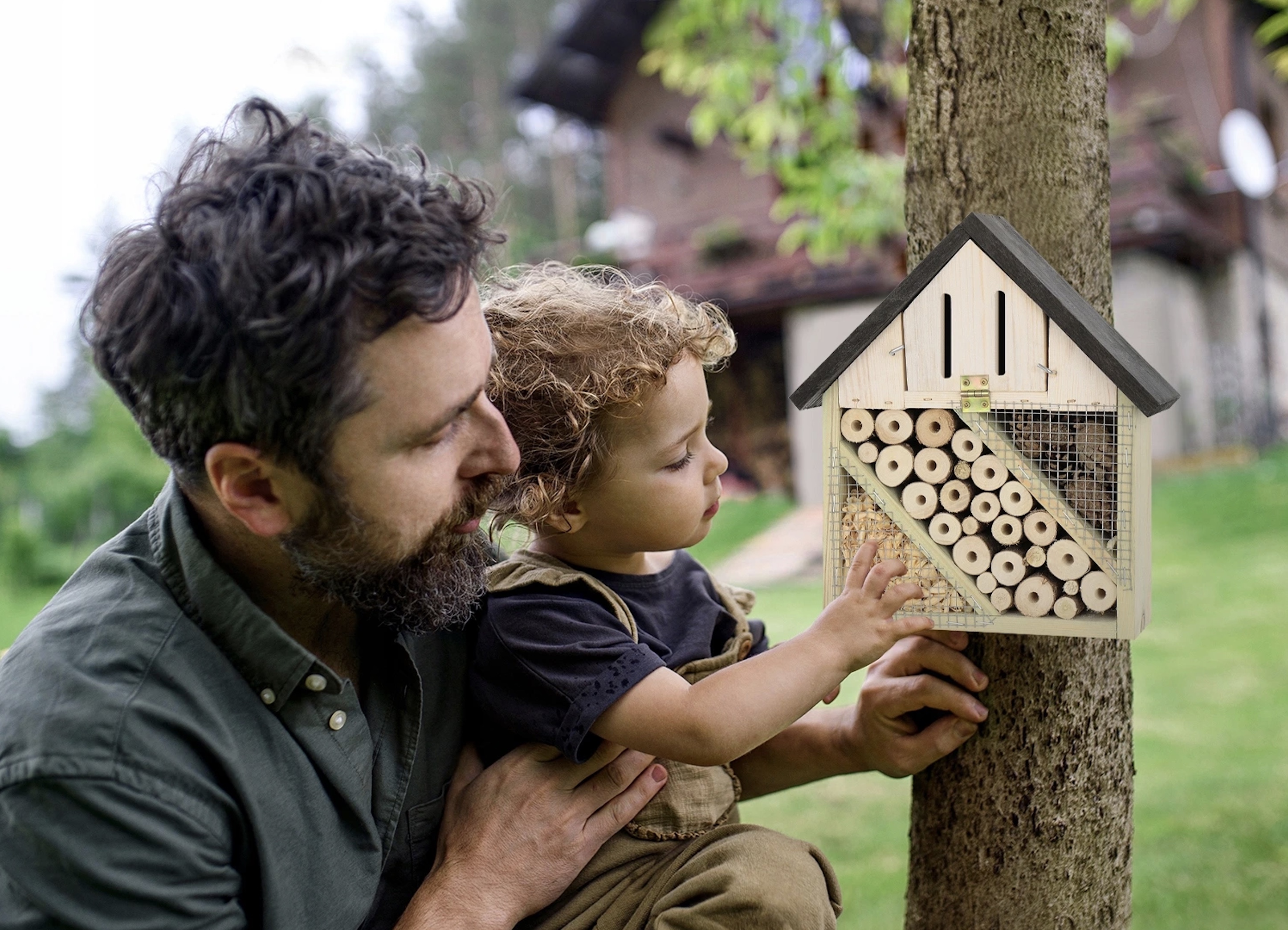 Otec s dieťaťom inštalujú hmyzí hotel v záhrade