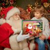 Santa Claus odovzdáva chlapcovi adventný kalendár so slizom – vianočný darček pre deti