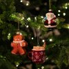 Sklenené vianočné ozdoby na stromček – perníček, Santa Claus a hrnček s kakaom v teplej sviatočnej atmosfére