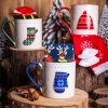 Vianočný darčekový set Hrejivé Vianoce – keramický hrnček s modrou rukavicou a ponožky so sobíkmi v zimnom aranžmáne
