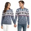 Zladený pár v jeansovo-modrých vianočných svetroch s bielym nórskym vzorom, sobmi a vločkami – ideálne pre zimnú pohodu vo dvojici