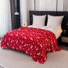 Hrejivá červená prikrývka s vianočným vzorom sobov a hviezd – vytvára útulnú atmosféru v spálni počas sviatkov