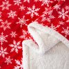 Detail červenej vianočnej deky s jemným barančekom a vzorom snehových vločiek – hebká prikrývka na zimné dni