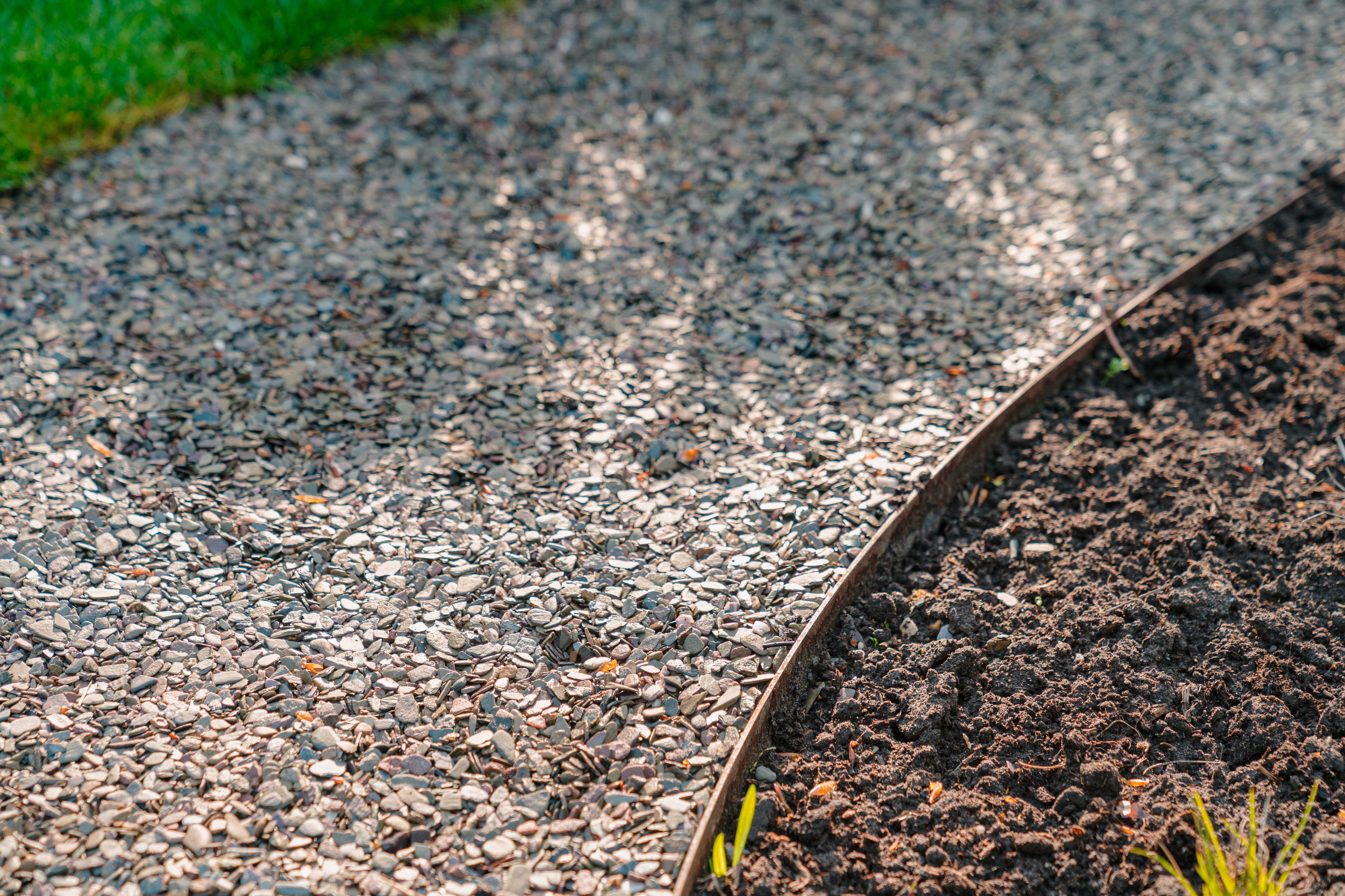 Cortenové zahradní lemy oddělující trávník a záhon