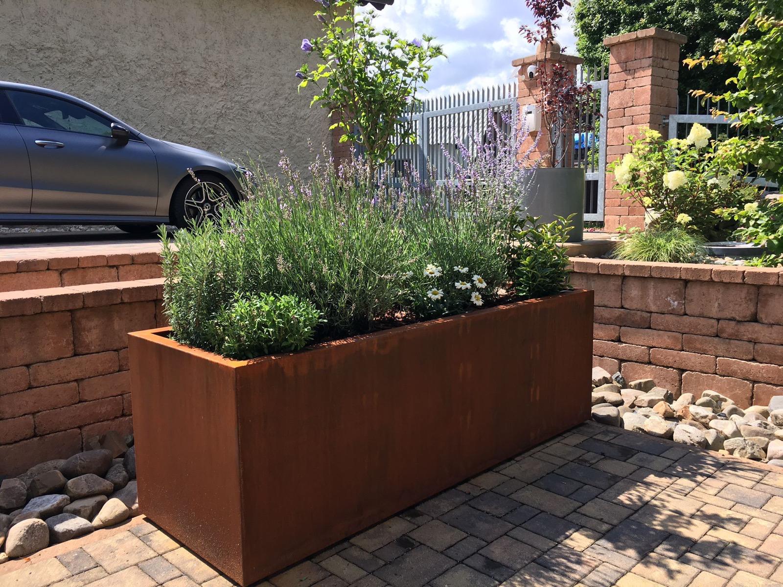 Cortenový květináč u terasy rodinného domu