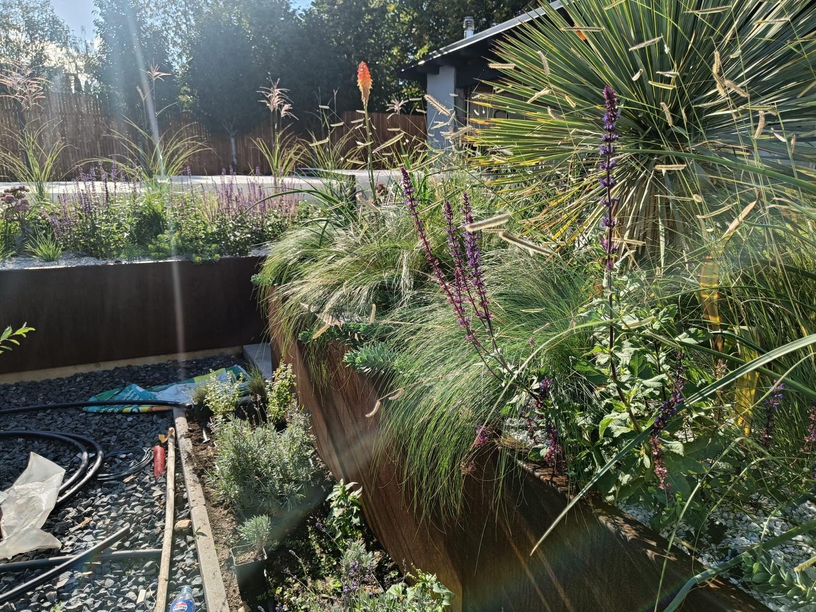 Zahrada s cortenovými květináči a štěrkovým záhonem