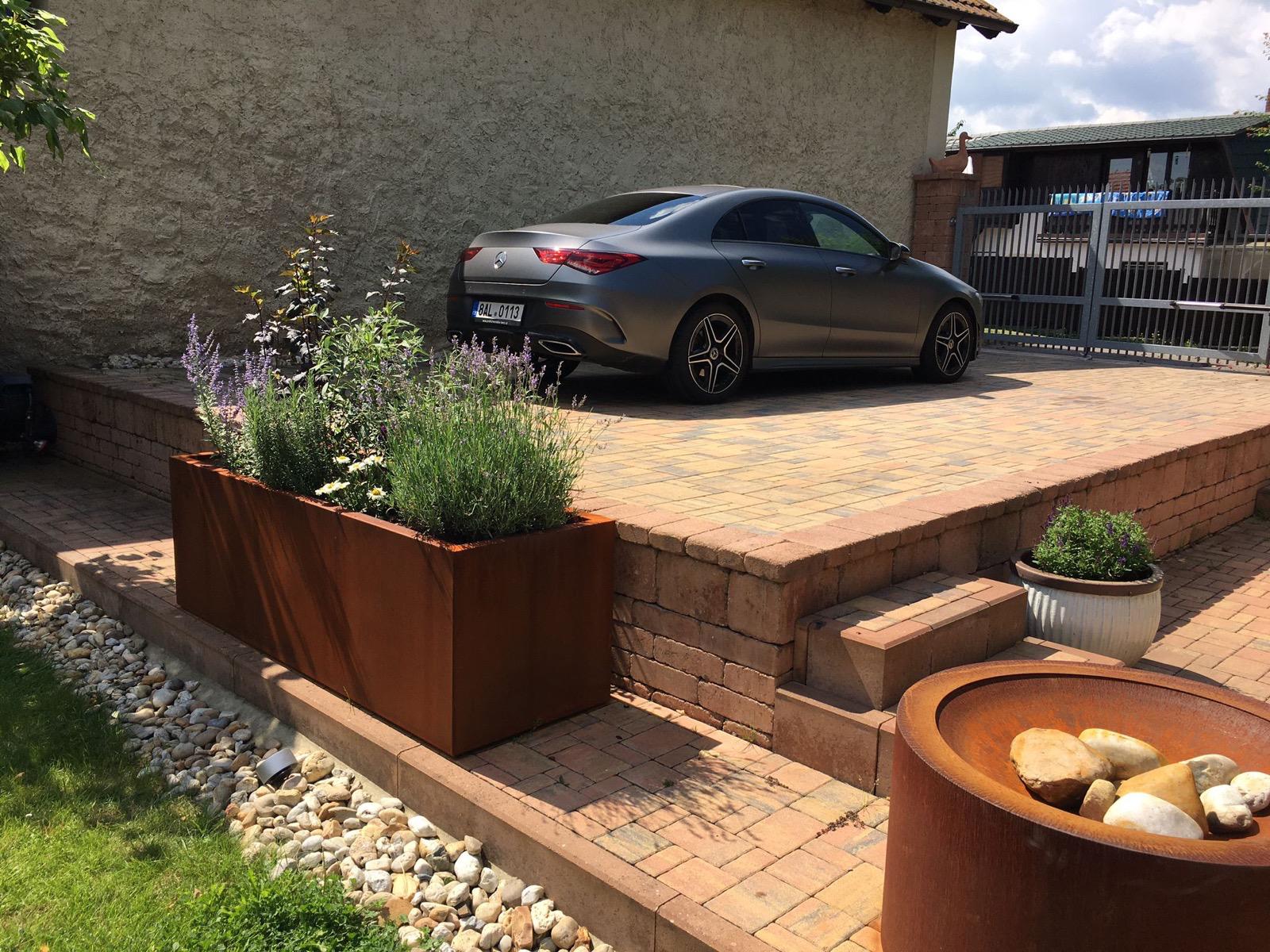 Pohled přes cortenový květináč do zahrady