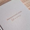 Detail světlé textilní vazby produktivního diáře se zlatou ražbou, ideální pro plánování a journaling