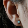 Titanový labret piercing s vnitřním závitem a bílým opálem.