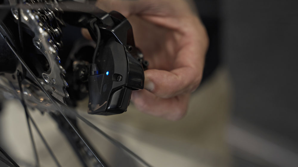 Shimano Di2 - synchronizačné tlačidlo na prehadzovačke pre doladenie radenia na výjazde