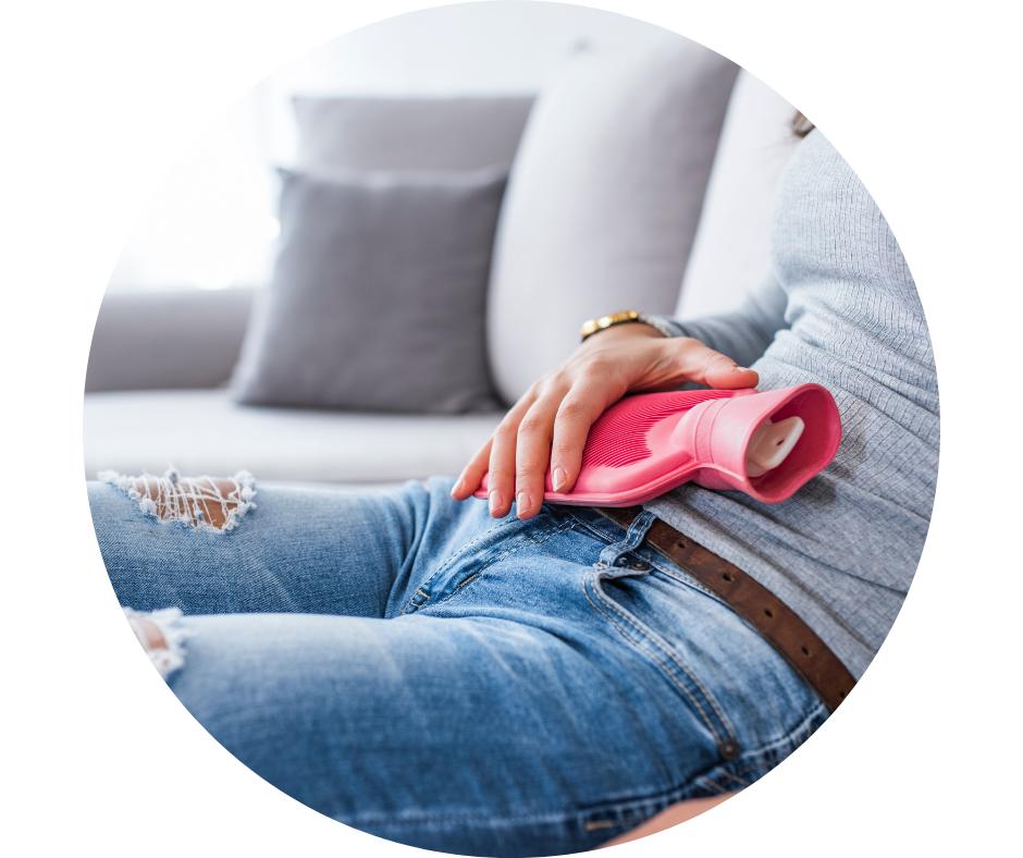 žena, která má termofor na břiše, kvůli bolestivé menstruace