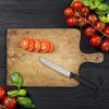 Ripe red cherry tomatoes with fresh basil leaves on black wooden table top view with copy space