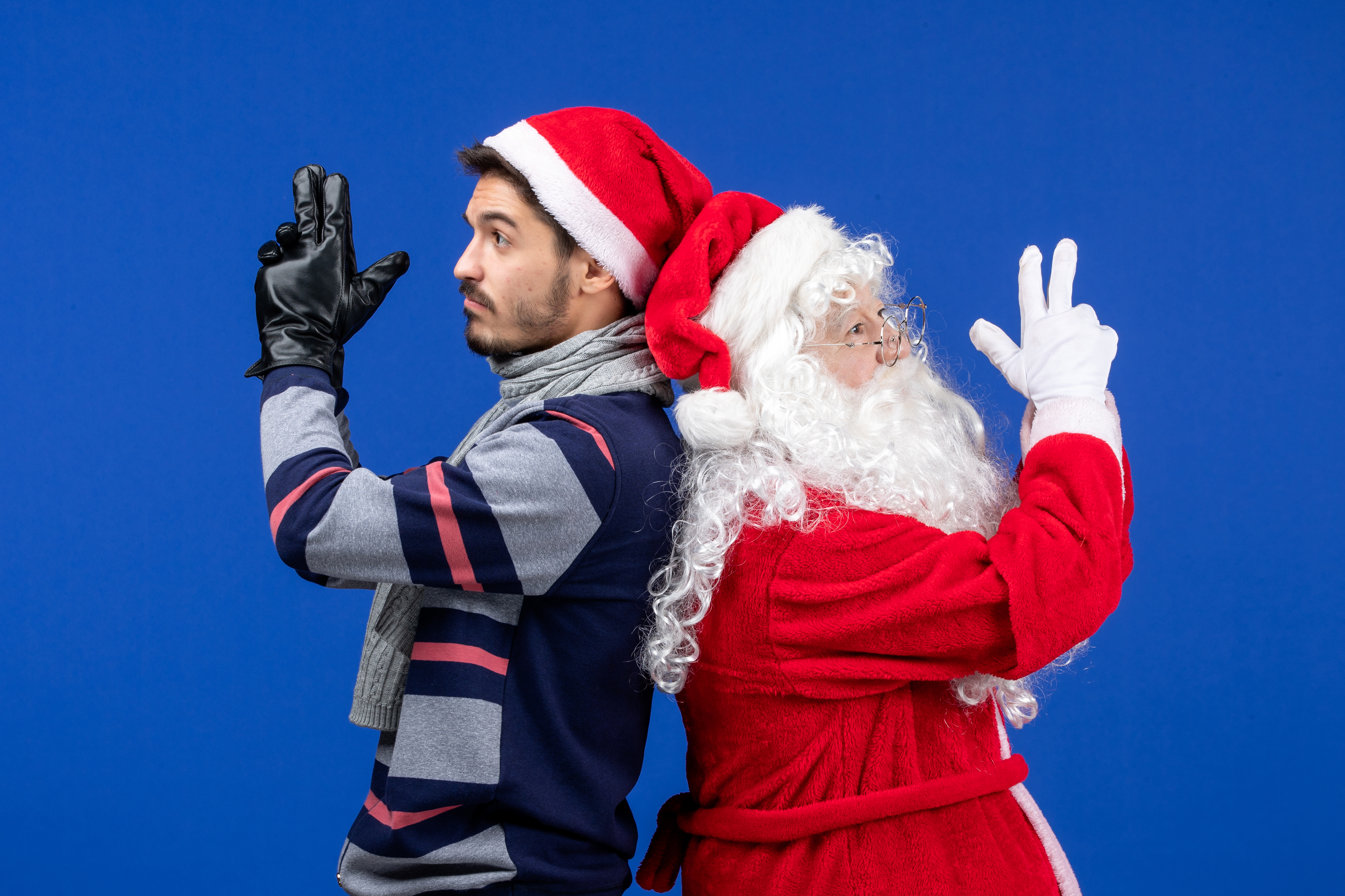 front-view-santa-claus-with-young-man-posing-blue-wall
