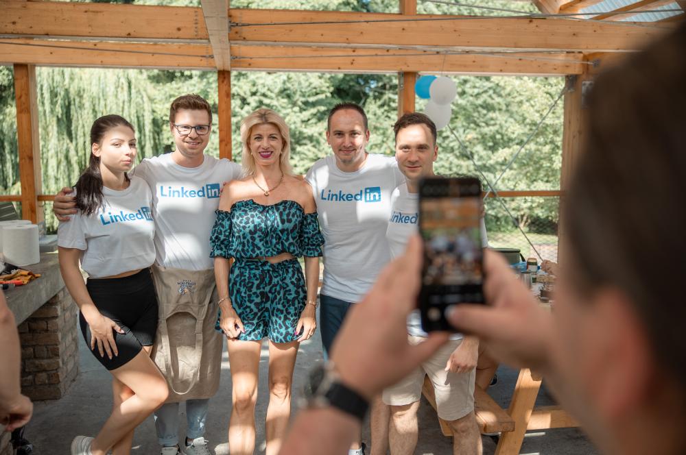 Ľudia stojaci pod dreveným altánkom počas Summer Networking 2024 s Lukášom Bednárom