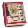 Dárkový balíček v červené elegantní krabici s průhledným víkem, uvnitř s vínem Châteauneuf du Pape, delikatesami a kakaovými lanýži Mathez